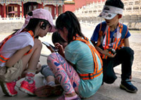 kleine kinderen die met hun telefoon spelen in de Forbidden City in Beijing, China